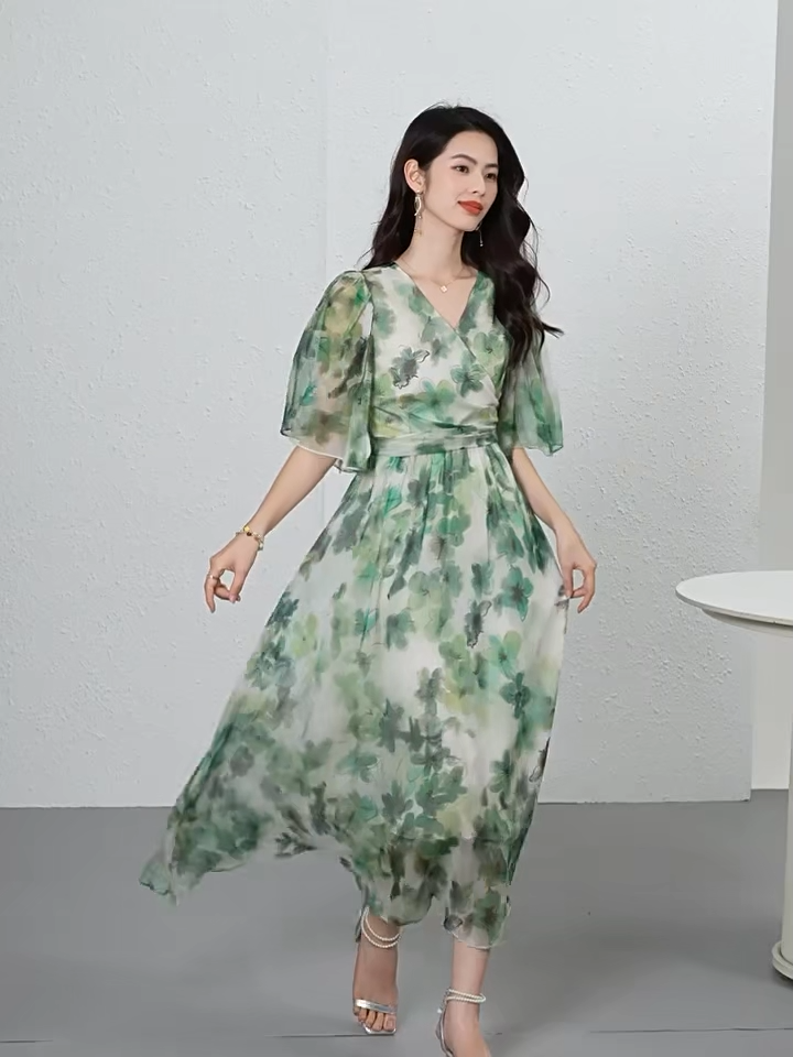 Video showcasing a Translucent Jade Breeze silk georgette midi dress with a wrap bodice, 1/2 flutter sleeves, and watercolor jade floral patterns on a misty background. — From Borcelleclothes.