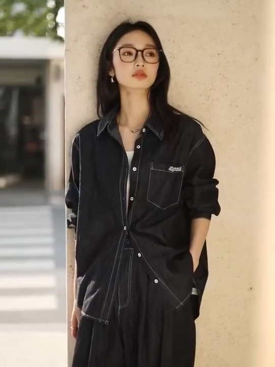 Video showcasing a Women’s two-piece set in Midnight Express color featuring a loose-fit shirt with SPROUT embroidery and contrast topstitching, paired with wide-leg tucks trousers. From Borcelleclothes.