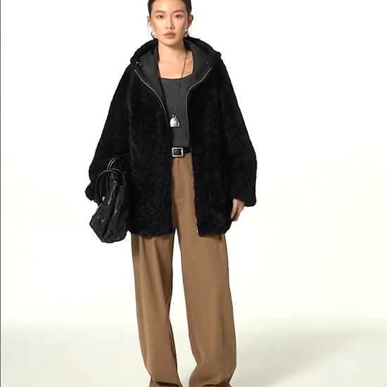 Video showcasing a Women's reversible shearling coat with hood, crafted from Lacaune lamb, featuring the short coiled texture, shown in Night Swirling — From Borcelleclothes.