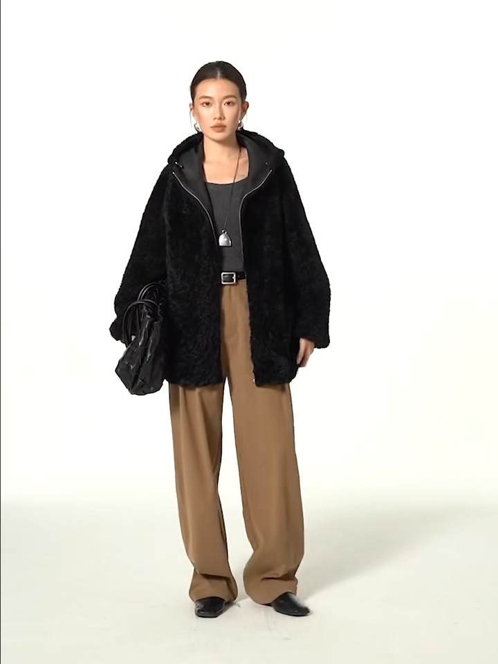 Video showcasing a Women's reversible shearling coat with hood, crafted from Lacaune lamb, featuring the short coiled texture, shown in Night Swirling — From Borcelleclothes.