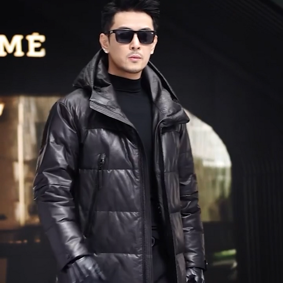 Video showcasing a Men’s sheepskin down jacket in Onyx with large diagonally zippered pockets, exposed central closure, sculptural hood, and tonal imprint under the collar — From Borcelleclothes.