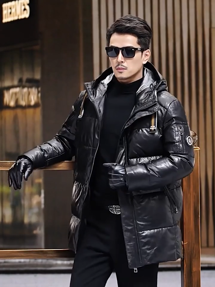 Video showcasing a Men's Onyx goatskin down coat with striped belt at hood, two-way zip into hood, diagonal zip pockets, reflective lining, mid-calf length — From Borcelleclothes.