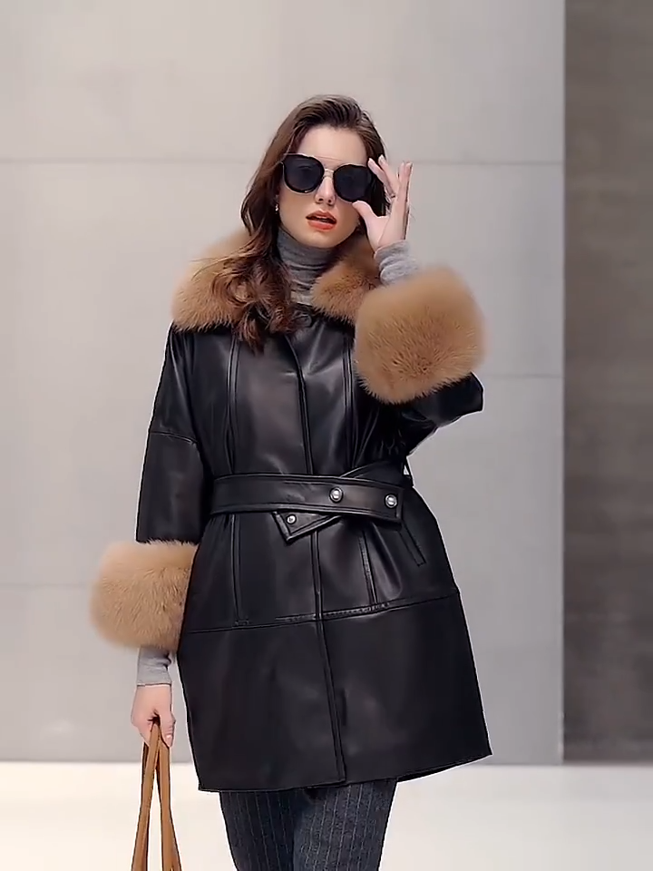 Video showcasing a Women’s sheepskin coat in Light French Beige and Onyx colors, with fox fur collar and kimono sleeves, belted waist, and thigh-length silhouette. — From Borcelleclothes.
