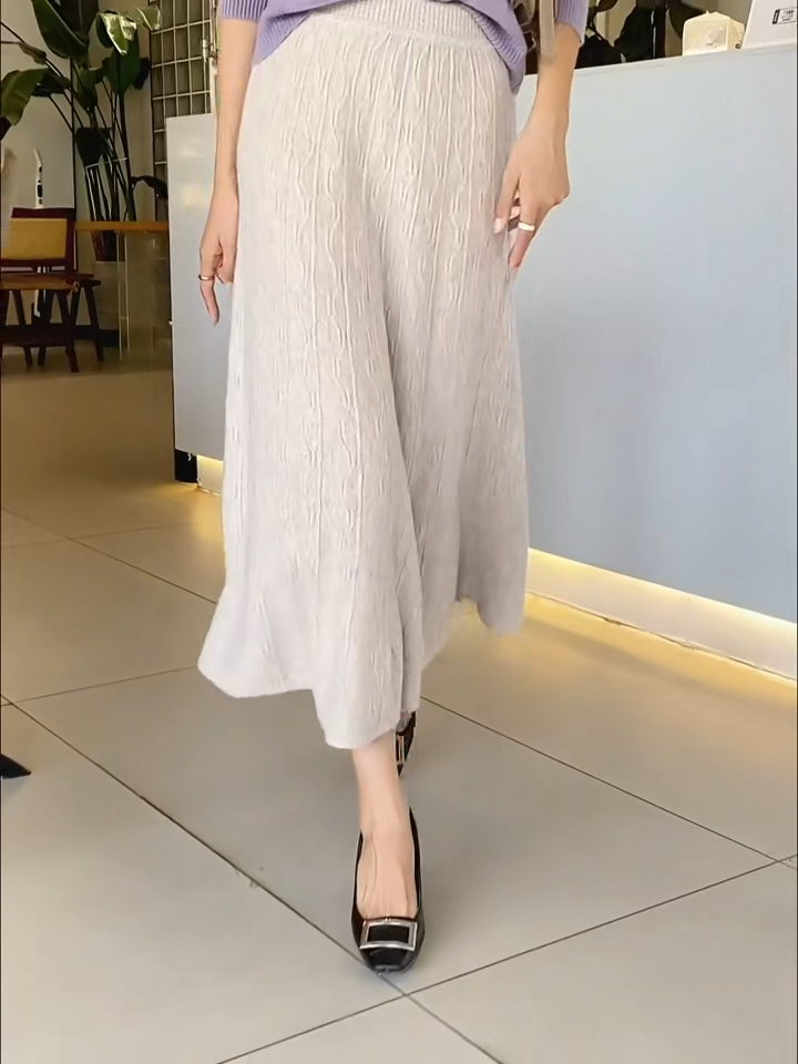 Video showcasing a Women's A-line merino wool skirt in Pale Silver, with vertical and wave-textured knit, mid-calf length, in soft premium fabric — From Borcelleclothes.