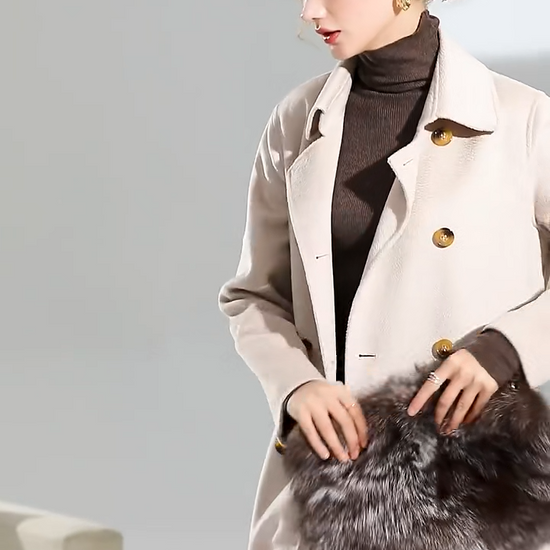 Video showcasing Women's Structured Wool Coat in Pearl Bush—a mid-calf double-breasted silhouette with a pointed collar, adjustable belt, and a softly neutral hue. From Borcelleclothes