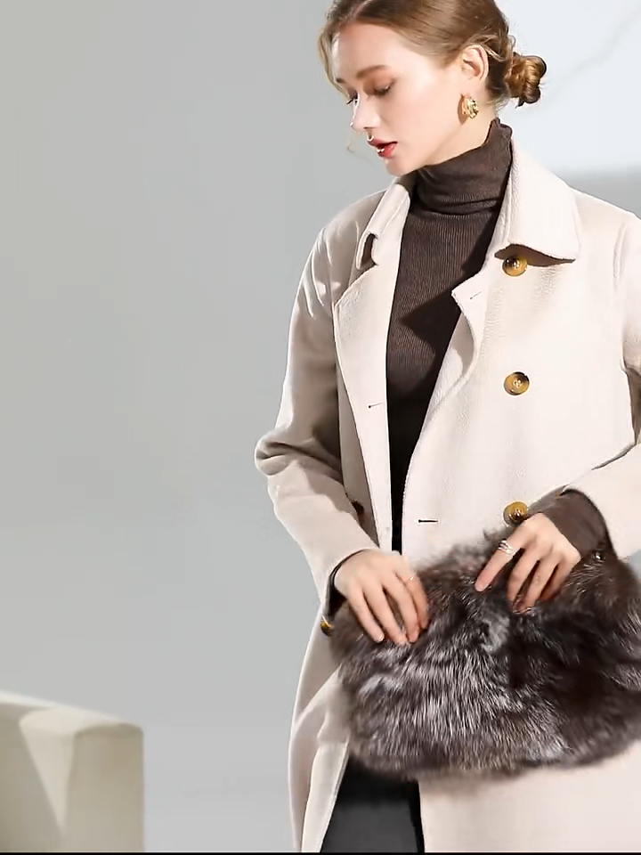 Video showcasing Women's Structured Wool Coat in Pearl Bush—a mid-calf double-breasted silhouette with a pointed collar, adjustable belt, and a softly neutral hue. From Borcelleclothes