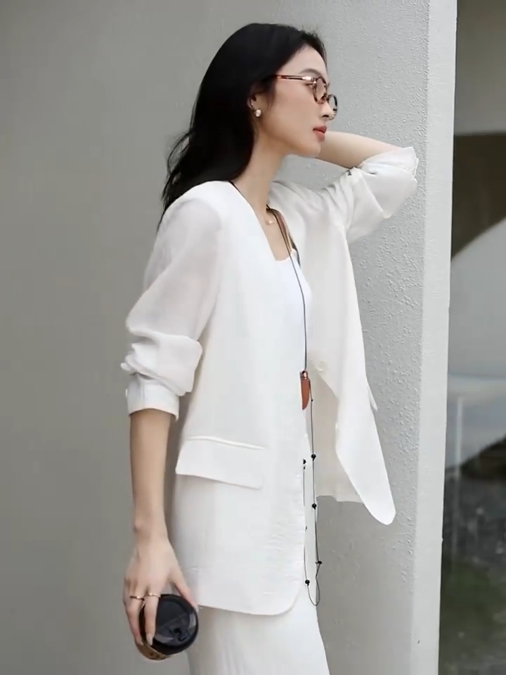 Video showcasing a Women's textured pinstripe crinkle blazer in Pearl Bush, hip-length with a clean V-neckline, defined by freedom. From Borcelleclothes.