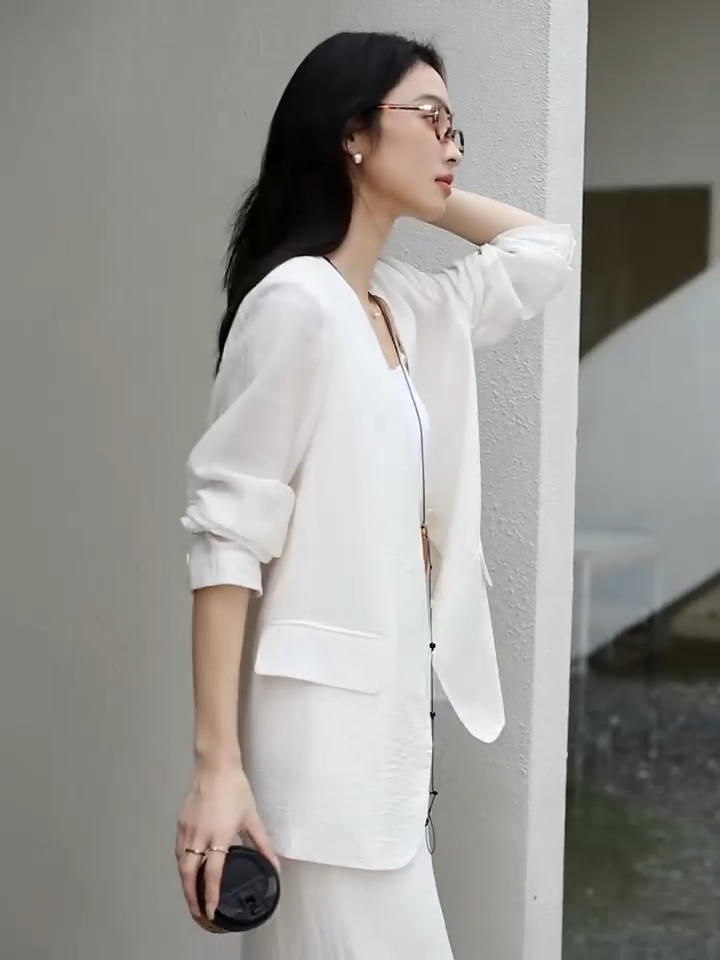 Video showcasing a Women's textured pinstripe crinkle blazer in Pearl Bush, hip-length with a clean V-neckline, defined by freedom. From Borcelleclothes.