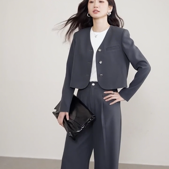 Video showcasing a Gris Phénix set: a grey cropped single-breasted jacket with rounded edges and molten metal buttons paired with straight-cut pleated trousers. — From Borcelleclothes.