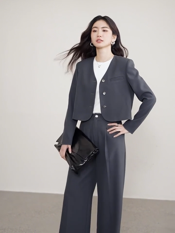 Video showcasing a Gris Phénix set: a grey cropped single-breasted jacket with rounded edges and molten metal buttons paired with straight-cut pleated trousers. — From Borcelleclothes.