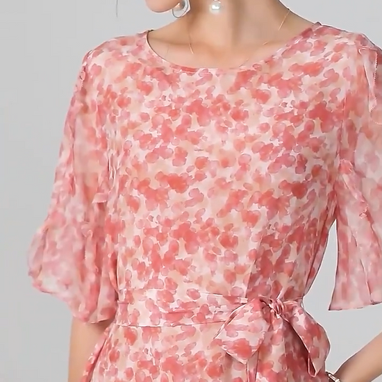 Video showcasing a Mulberry silk chiffon dress with abstract floral print in rose tones, featuring a round neckline, matching belt, and softly flowing volume. From Borcelleclothes.