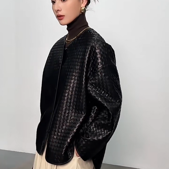 Video showcasing a Women's Sculptural hand-woven sheepskin nappa jacket in Quicksilver Noir. Featuring diagonal geometric weaving, relaxed silhouette, and curved leather-bound edges. — From Borcelleclothes.