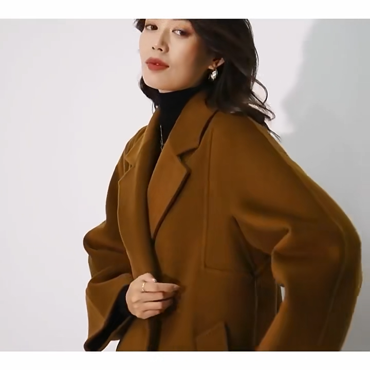 Video showcsing a Women's Wrap Coat Redefined in all colors—crafted from a luxurious blend of Merino wool and cashmere. Featuring square gussets for a structured silhouette, notch lapels, a single-welt pocket design, and an adjustable belt, this mid-calf wrap coat blends modern tailoring with timeless elegance. From Borcelleclothes.