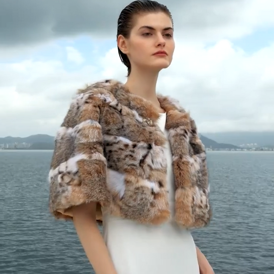 Video showcasing a Women's Lynx fur cape in Shades of Forest — featuring a rounded cut, wild-spotted full-length pelts, and a sculpted gold-tone hook at the neckline. — From Borcelleclothes. 