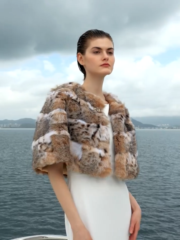 Video showcasing a Women's Lynx fur cape in Shades of Forest — featuring a rounded cut, wild-spotted full-length pelts, and a sculpted gold-tone hook at the neckline. — From Borcelleclothes. 