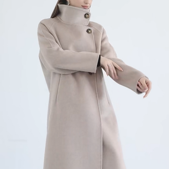 Video showcasing s Women's long, wrap-style double-sided wool coat in Sultana Spice, with an asymmetrical silhouette, saddle sleeves, and a high stand-up collar. — From Borcelleclothes.
