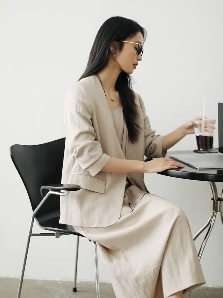 Video showcasing a Women’s two-piece set in Swiss Coffee color featuring a single-breasted jacket with long sleeves and an A-line camisole dress with adjustable straps. From Borcelleclothes.
