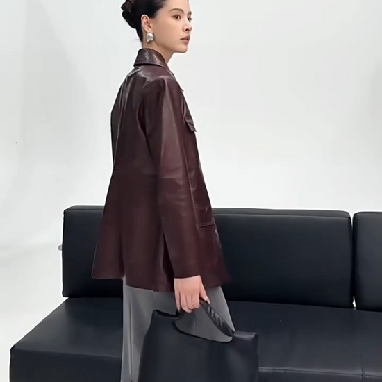 Video showcasing a Women's Full-grain oil-waxed sheepskin jacket in deep Vintage Amarone. Features a belted safari silhouette, buttery drape, and a dynamic pull-up finish. — From Borcelleclothes.