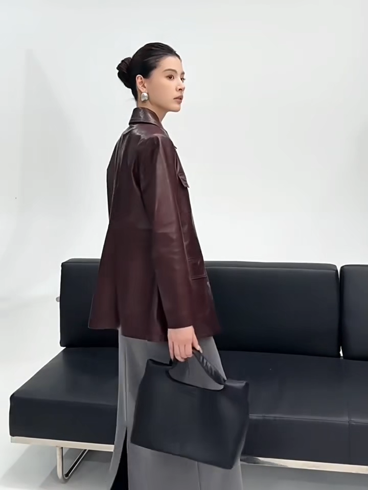 Video showcasing a Women's Full-grain oil-waxed sheepskin jacket in deep Vintage Amarone. Features a belted safari silhouette, buttery drape, and a dynamic pull-up finish. — From Borcelleclothes.