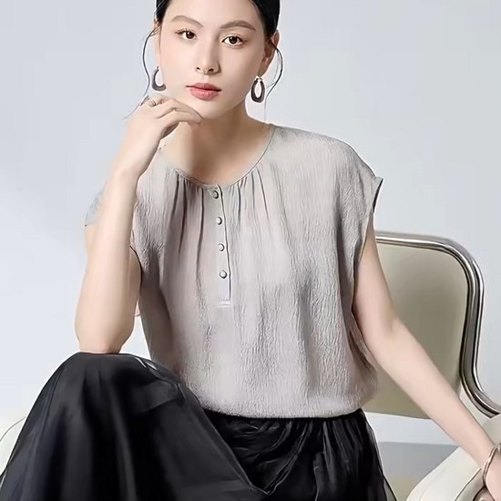 Video showcasing a Women's Loose-fitting 14 Momme Mulberry silk georgette blouse in Where Lives Nacre, with a micro-puckered jacquard texture. Features a Henley placket with mother-of-pearl cabochon buttons. — From Borcelleclothes.