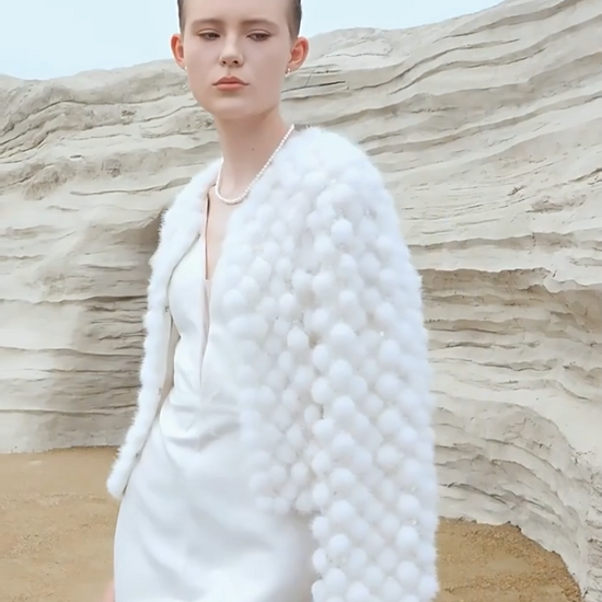 Video showcasing a Women’s mink mosaic coat made of individually attached sheared mink pom-poms and hand embroidery on mesh — in color White Whimsy. — From Borcelleclothes.