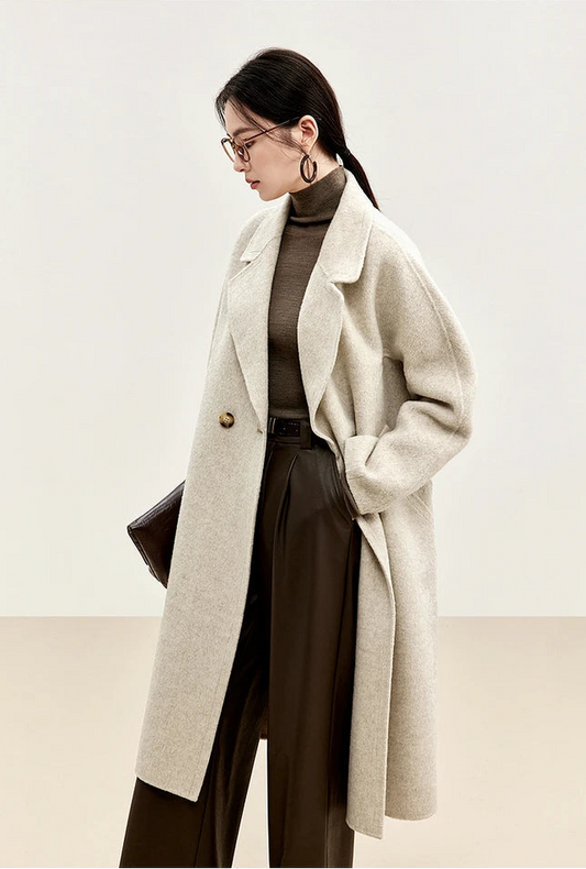 Model wearing an unfastened beige Alashan wool coat, side profile view — From Borcelleclothes.