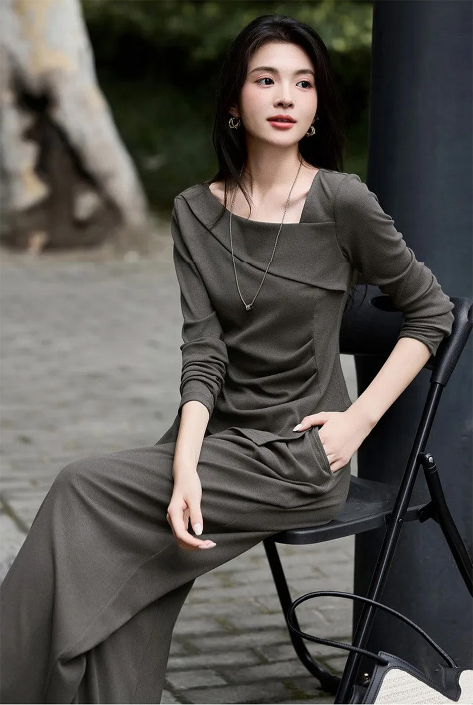 Woman sitting on a chair wearing a dark olive architectural ribbed knit set — From Borcelleclothes.