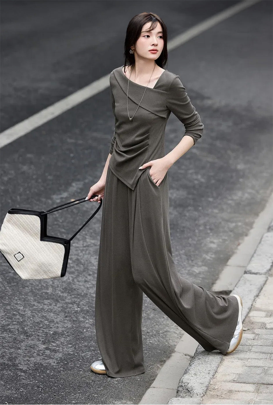 Side view of a woman walking in an asymmetrical high-low hem ribbed knit set — From Borcelleclothes.