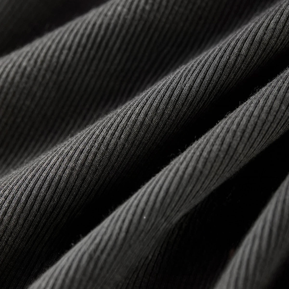 Close-up of high-stretch 1x1 ribbed knit fabric with folded wave texture — From Borcelleclothes.