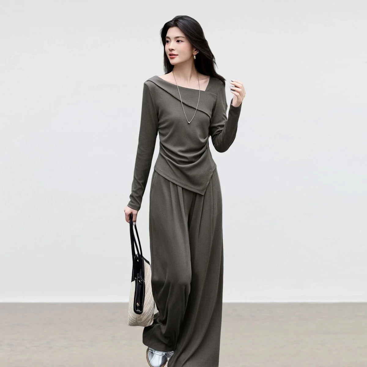 Women's asymmetrical ribbed knit set: long-sleeve top with folded diagonal neckline and waist draping, styled with wide-leg elasticated pants. — From Borcelleclothes.