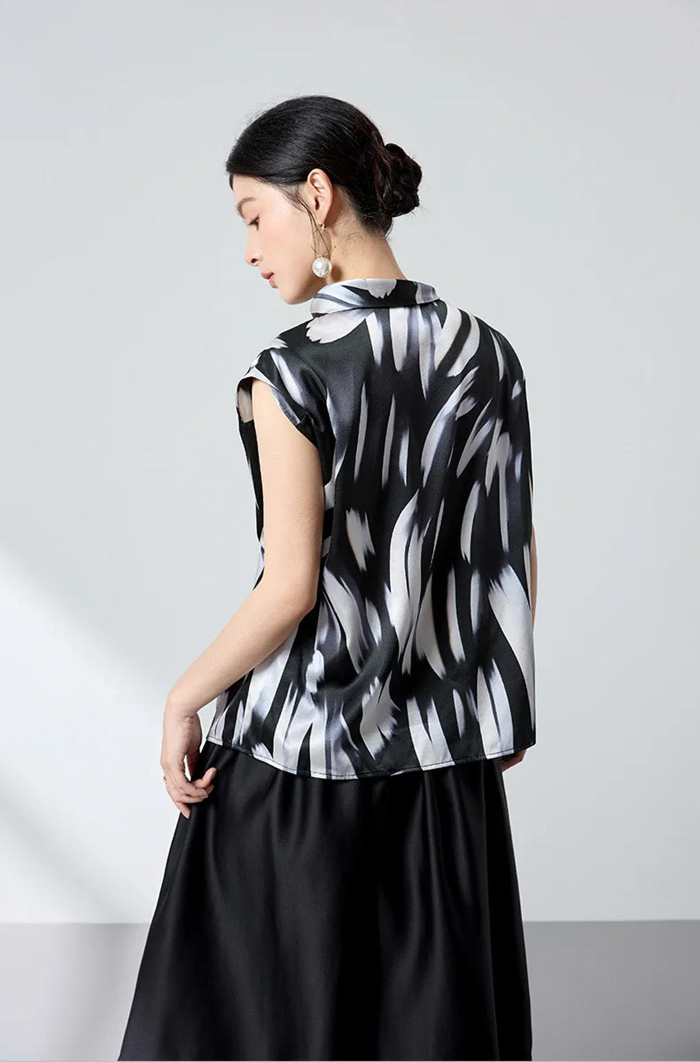 Back view of model wearing asymmetric neckline Mulberry silk satin blouse — From Borcelleclothes.