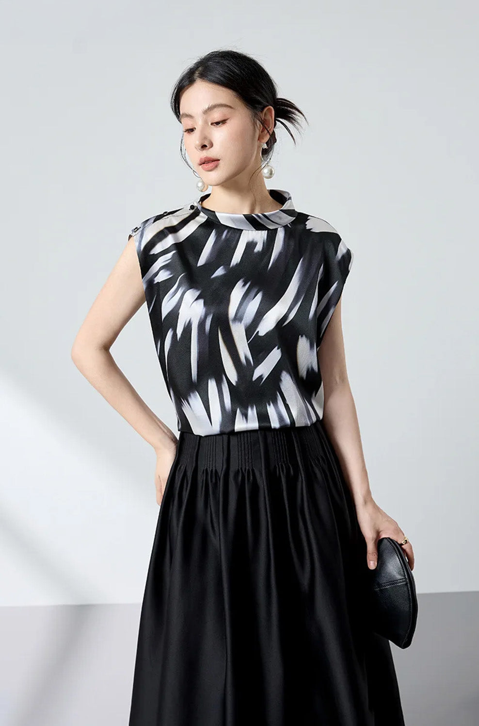 Model with hand on hip showcasing the draped silhouette of Fleeting Impulse silk top — From Borcelleclothes.