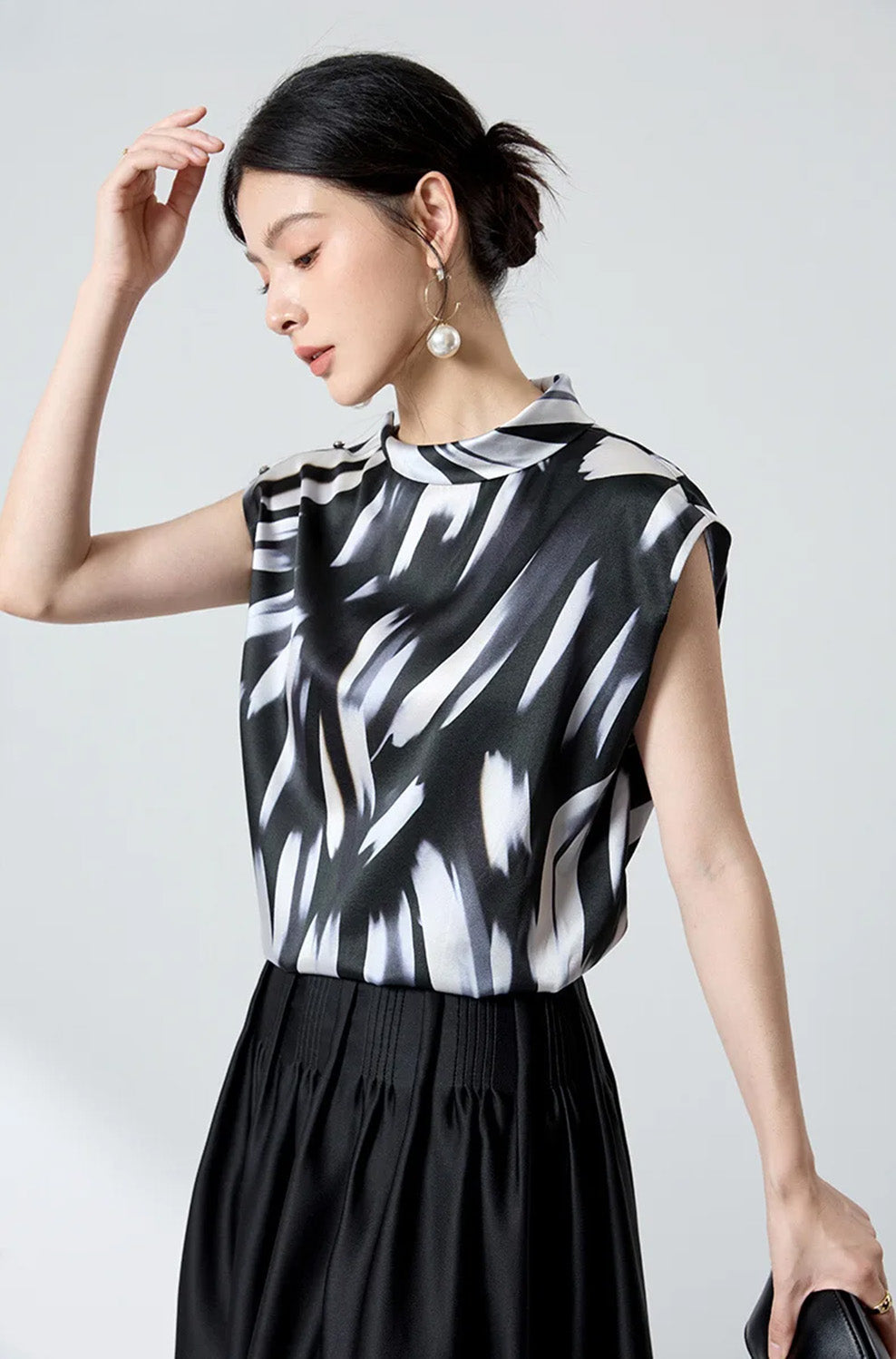 Model posing with raised arm near head in Fleeting Impulse silk satin top — From Borcelleclothes.
