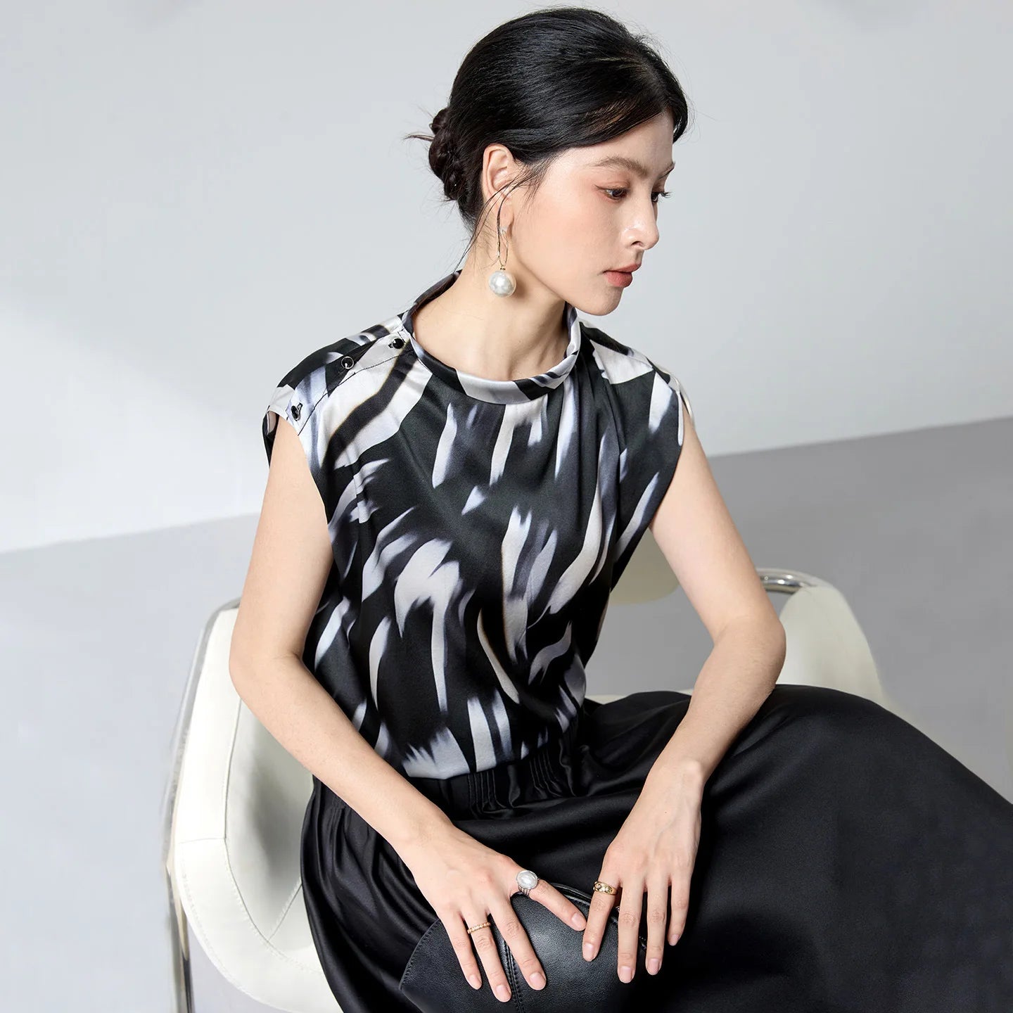 Women's 19 Momme Mulberry silk satin blouse in Fleeting Impulse. Features an asymmetric rounded fold-over collar and a shoulder placket fastening with crystal buttons. — From Borcelleclothes.
