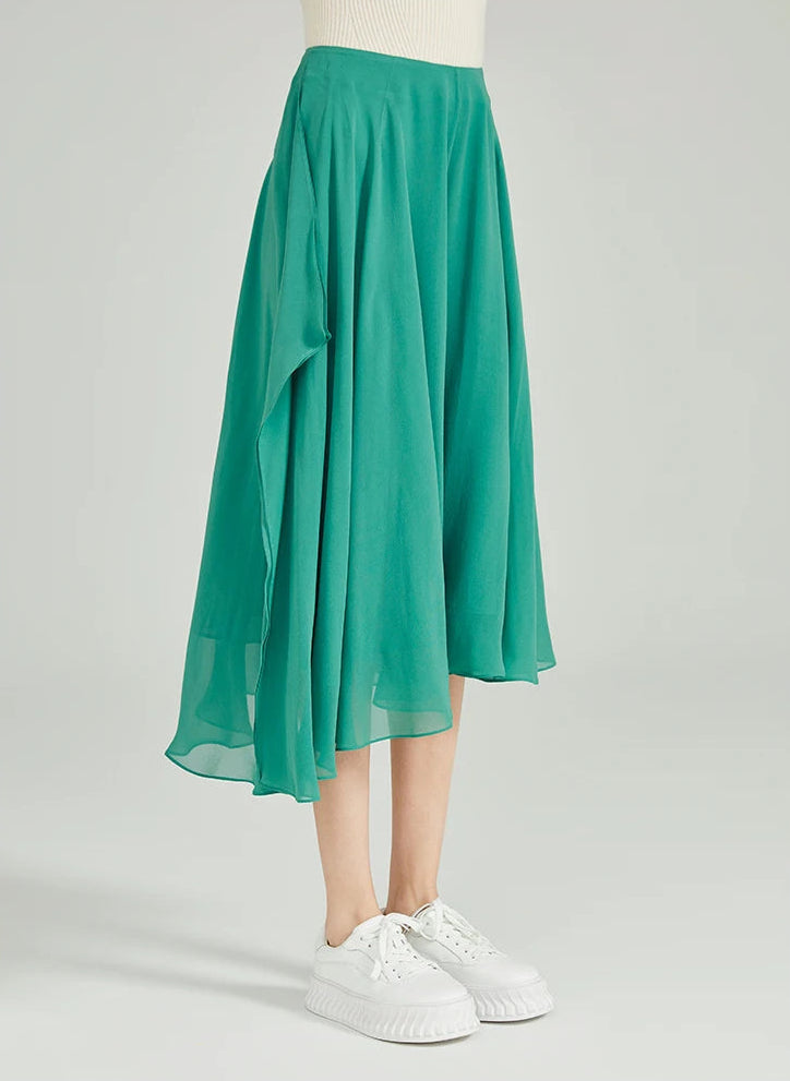 Model turned slightly to the side wearing wide-leg asymmetrical silk trousers in Meringue — From Borcelleclothes.