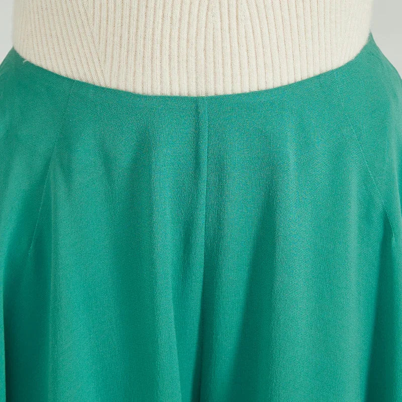 Close-up of front waist section on green Mulberry silk trousers showing smooth tailored fit — From Borcelleclothes.