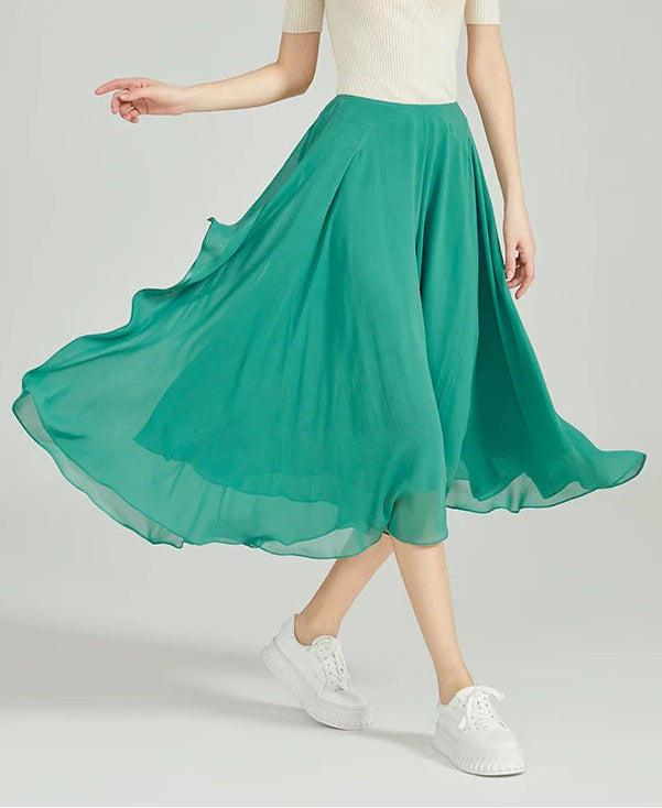 Model walking in green Mulberry silk georgette trousers with a soaring, fluid drape — From Borcelleclothes.