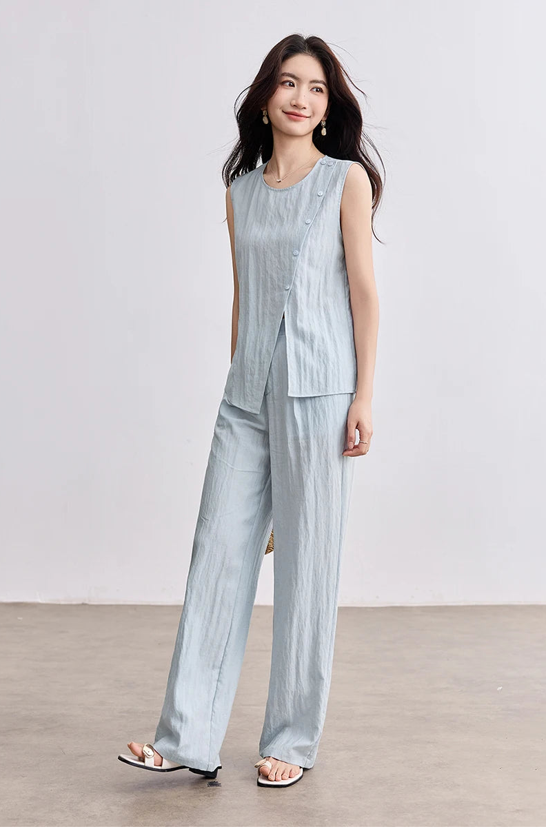 Full-length view of a woman in wide-leg trousers, subtly raising her toes on her right leg to show the fluid movement of the fabric — From Borcelleclothes.