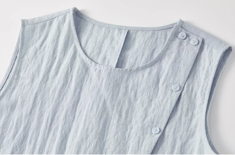 Close-up of the upper part of the asymmetrical top, showing the rounded neckline and sleeveless design — From Borcelleclothes.