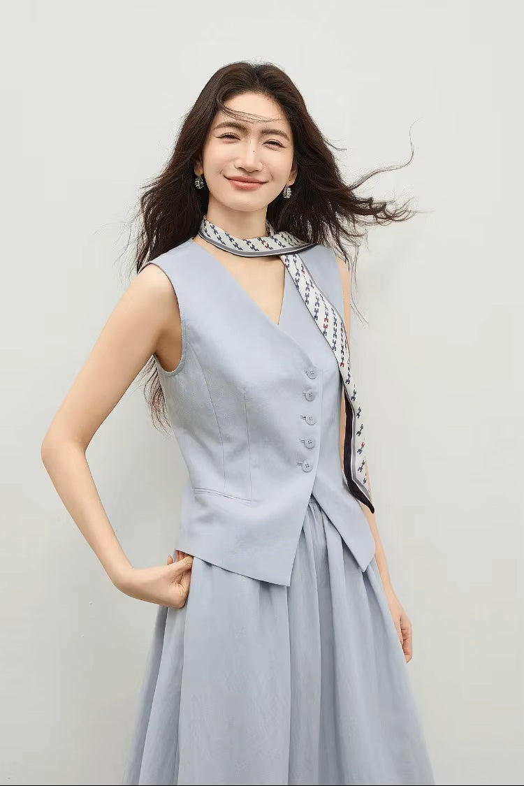 Close-up of a woman in a lavender structured vest, hand resting on the asymmetrical hemline — From Borcelleclothes.