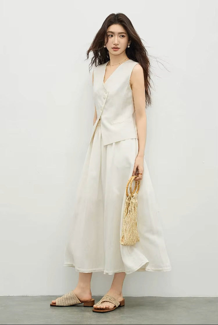 Profile view of a woman wearing a muted chord asymmetrical vest and flared skirt — From Borcelleclothes.