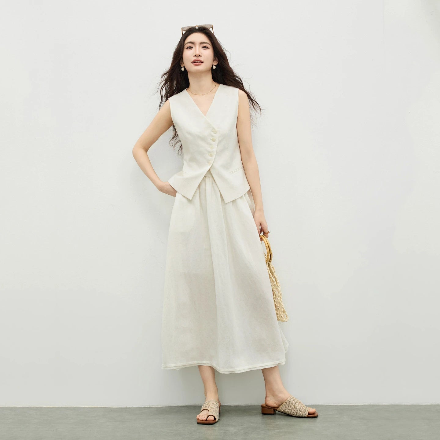 Women's two-piece set: sleeveless asymmetrical vest with tonal buttons and a flared midi skirt with an elasticated waistband. Shown in Muted Chord color. — From Borcelleclothes.
