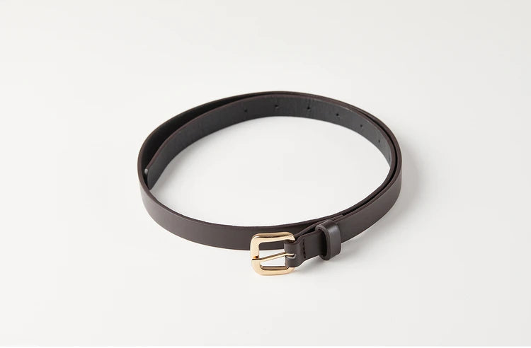 Detail of the slender leather belt cinching the waist of the asymmetrical wool vest — From Borcelleclothes.