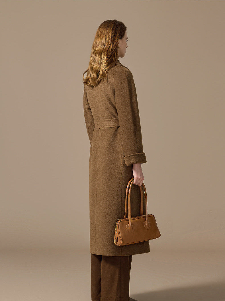 The architectural back view of a woman in the Gobi Haze coat, where precision tailoring meets natural grace. From Borcelleclothes.