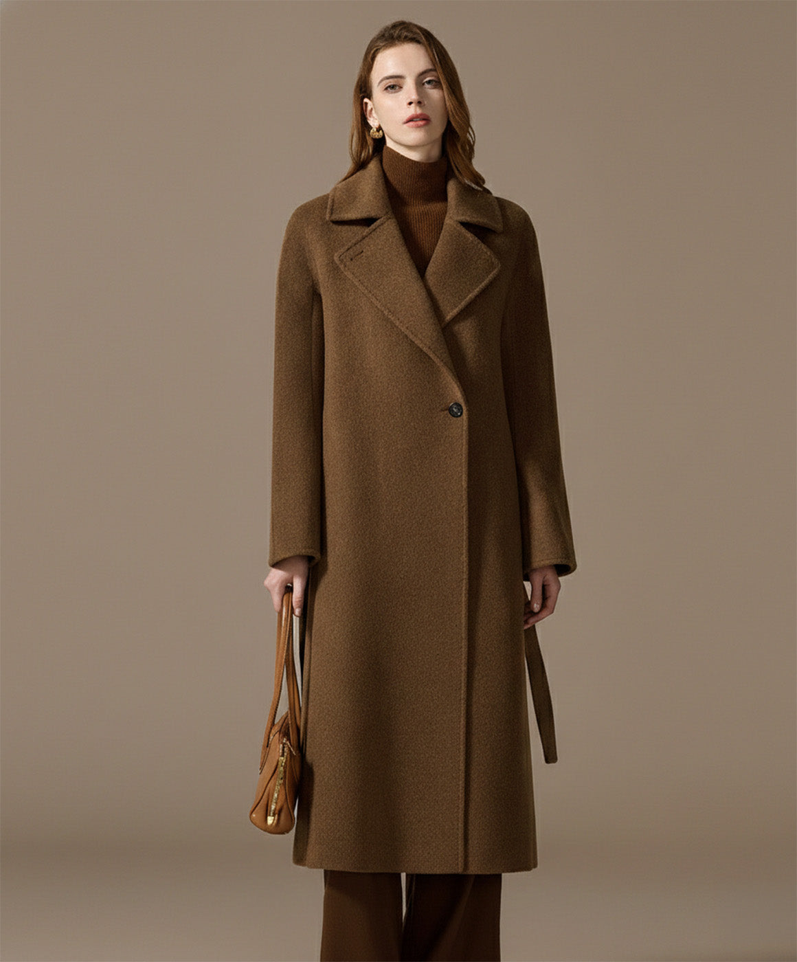 A woman wearing the Gobi Haze grey Bactrian camel hair coat, carrying a tonal bag for a minimalist look. From Borcelleclothes.
