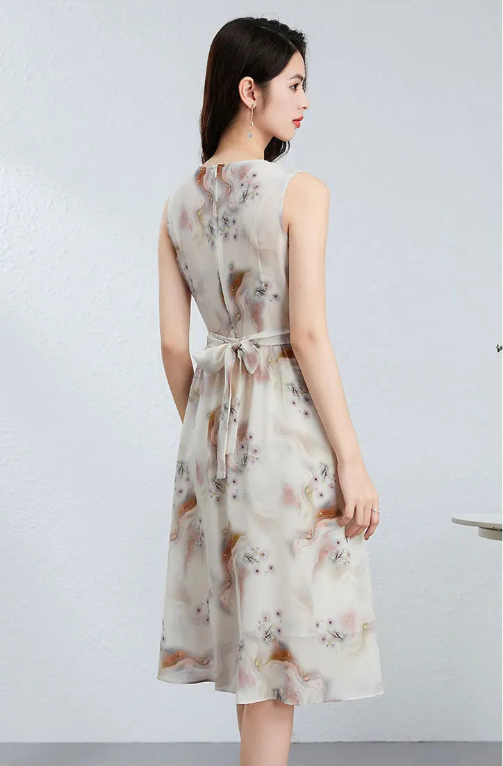Back view of a woman wearing the silk midi dress, showcasing the romantic bow tied at the waist and the elegant fall of the fabric — From Borcelleclothes.