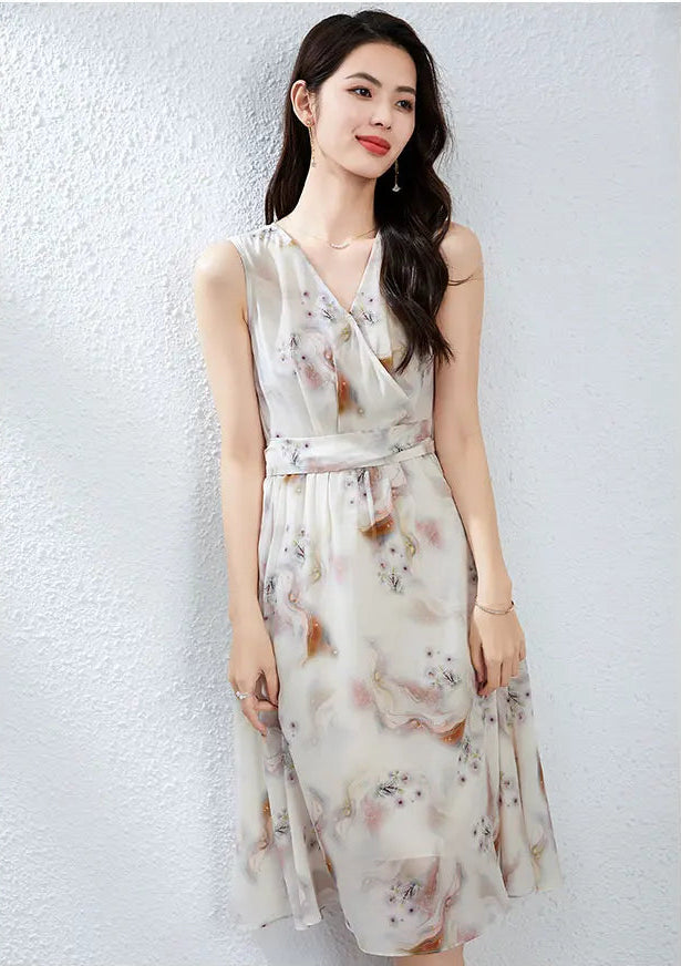 A woman standing gracefully with crossed legs, highlighting the fluid, airy movement of the flared silk midi skirt in misty watercolor print — From Borcelleclothes.