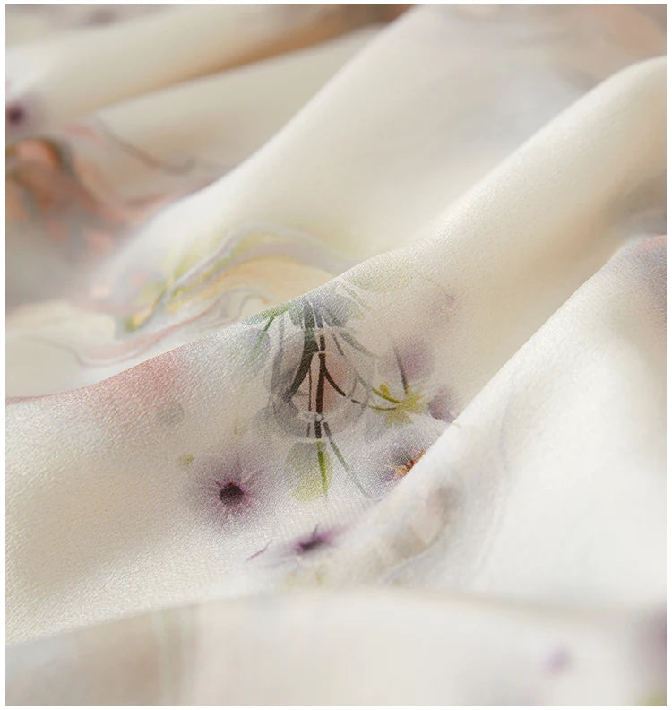 Close-up of wave-folded silk fabric showing the watercolor print of delicate dandelions dissolving into a milky morning fog — From Borcelleclothes
