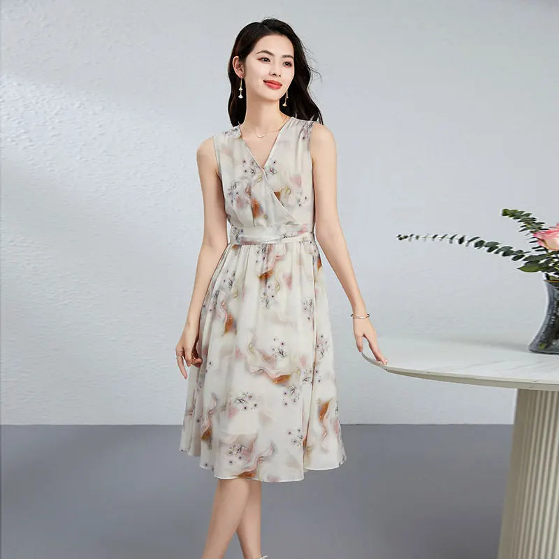 Women's flared sleeveless midi dress crafted from 100% Mulberry silk crepe de chine. Features a wrap bodice with pleats, side sashes, and a misty watercolor print. — From Borcelleclothes.