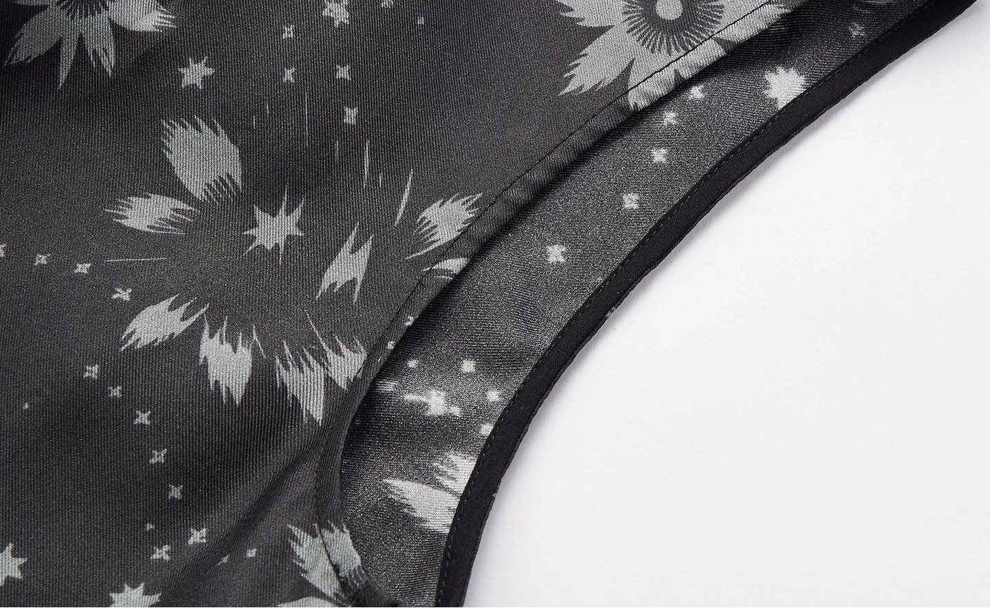 Macro shot of the clean-finished armhole and floral star print on dark graphite silk twill fabric — From Borcelleclothes.